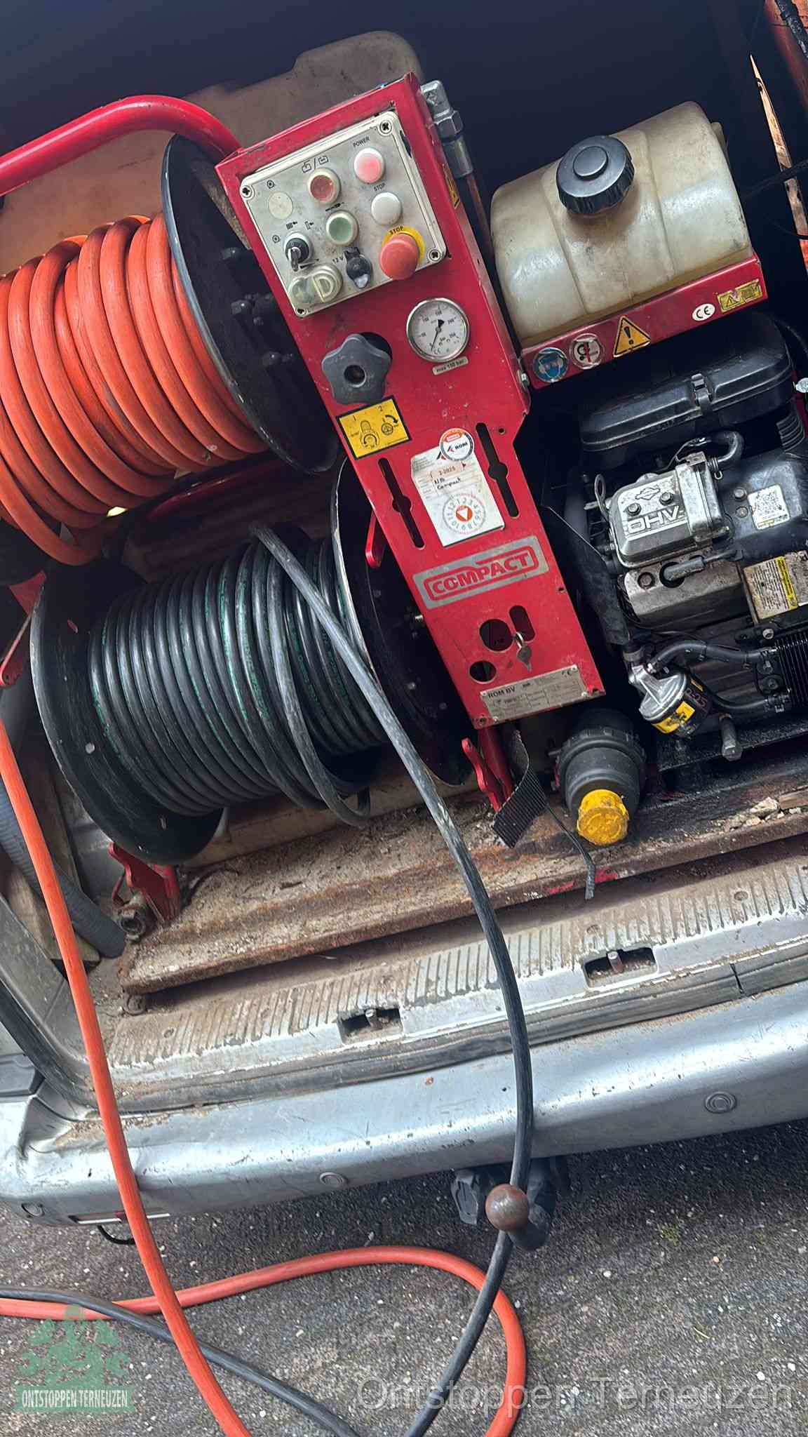 Een rood hogedruk-rioolreinigingstoestel in de laadbak van de bedrijfsbus, apparatuur voor een hardnekkige afvoerverstopping in Terneuzen
