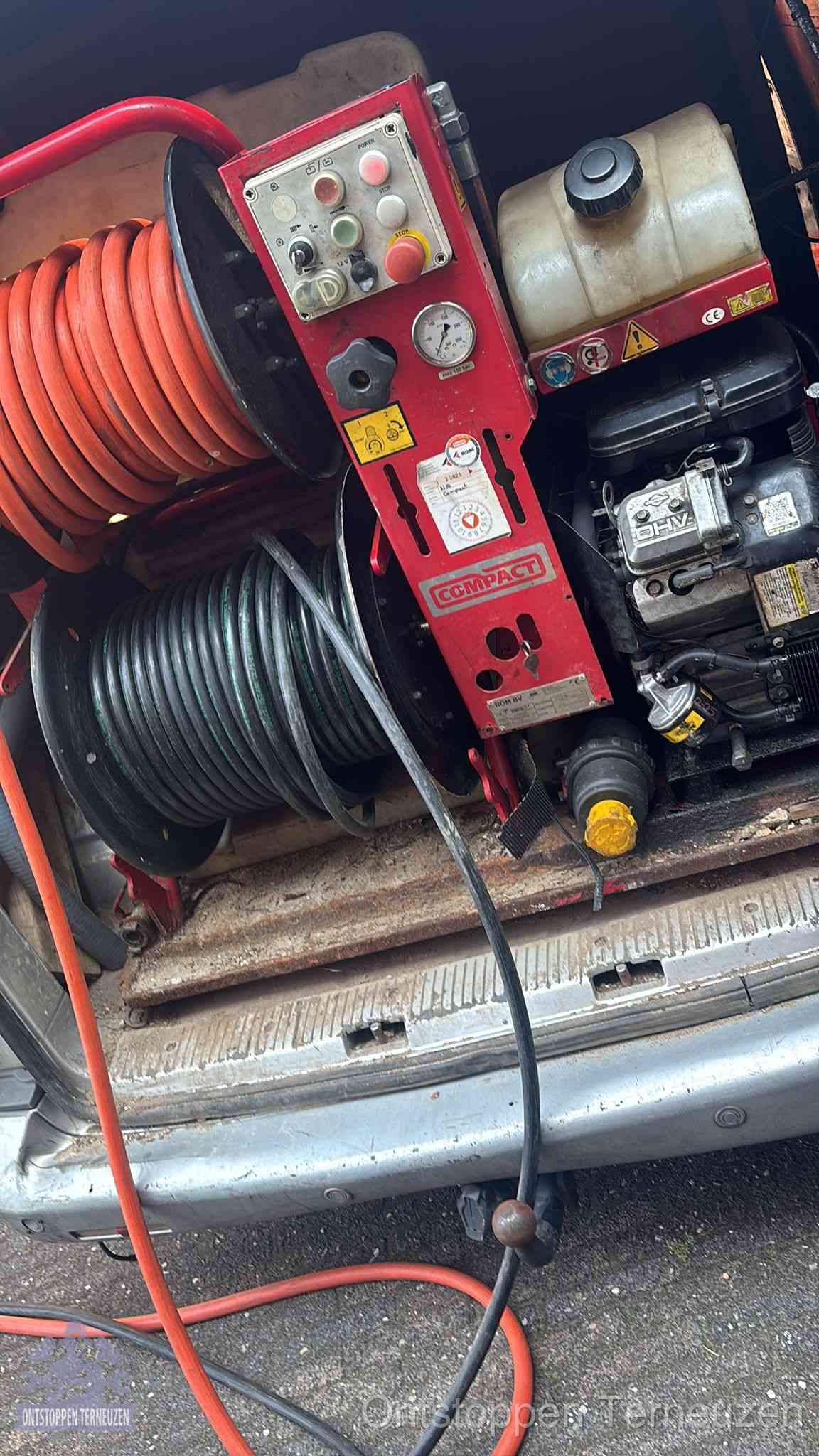 Een rood hogedruk-rioolreinigingstoestel met slangen in de laadbak van de bedrijfsbus, apparatuur voor een hardnekkige wc-verstopping in Terneuzen Een rood hogedruk-rioolreinigingstoestel met slangen in de laadbak van de bedrijfsbus, apparatuur voor een hardnekkige wc-verstopping in Terneuzen