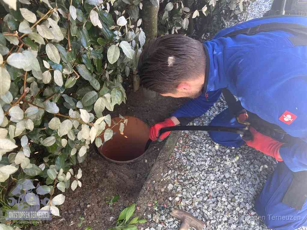 Monteur reinigt een rioolput met een slang, periodieke rioolreiniging in Terneuzen Monteur reinigt een rioolput met een slang, periodieke rioolreiniging in Terneuzen