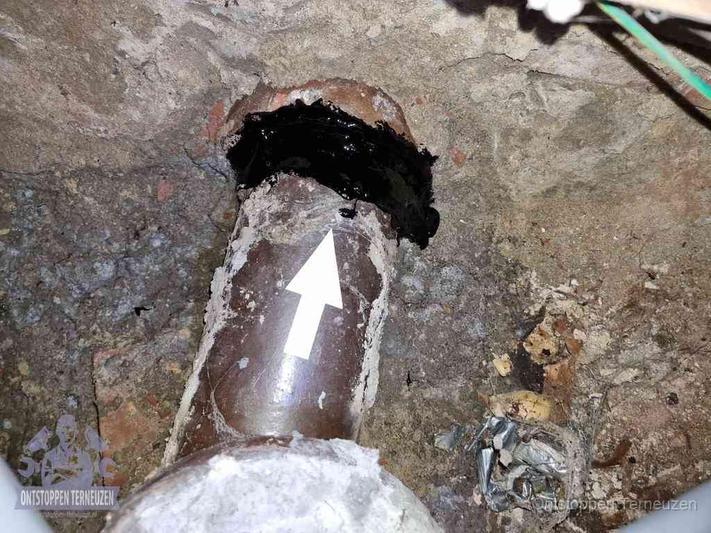 Een oude gres rioolbuis met een beschadigde koppeling onder de vloer, oorzaak van terugkerende structurele wc-problemen in Terneuzen Een oude gres rioolbuis met een beschadigde koppeling onder de vloer, oorzaak van terugkerende structurele wc-problemen in Terneuzen