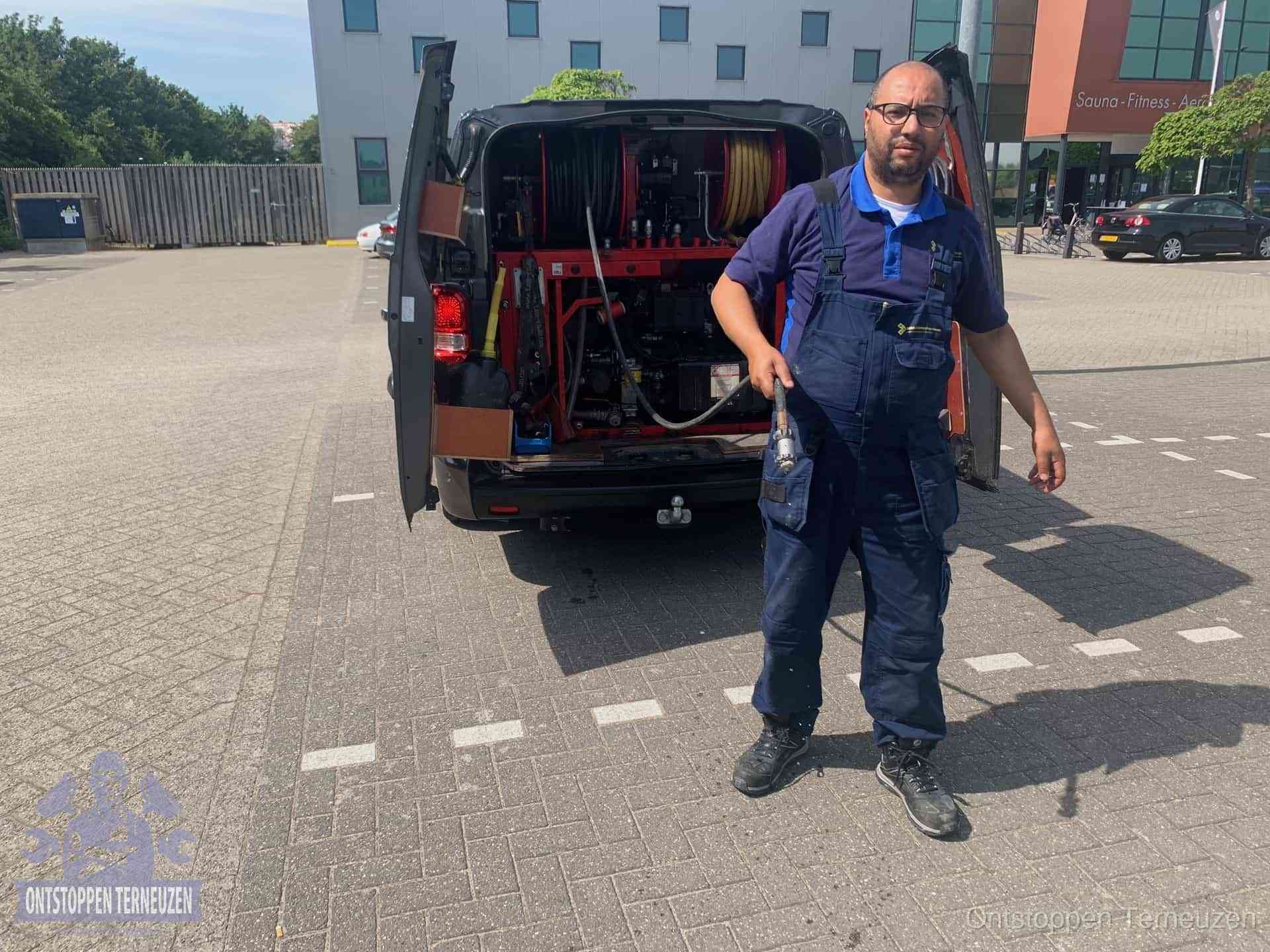 Een monteur bij zijn bestelbus met een hogedruk- en rioolreinigingsunit, klaar om de oorzaak van terugkerende wc-verstoppingen aan te pakken in Terneuzen Een monteur bij zijn bestelbus met een hogedruk- en rioolreinigingsunit, klaar om de oorzaak van terugkerende wc-verstoppingen aan te pakken in Terneuzen