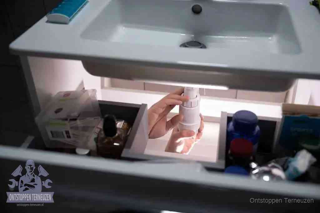 Een pompfles met zeep boven een wastafel in de toiletruimte, de warm water en afwasmiddel-methode om de wc te ontstoppen in Terneuzen Een pompfles met zeep boven een wastafel in de toiletruimte, de warm water en afwasmiddel-methode om de wc te ontstoppen in Terneuzen