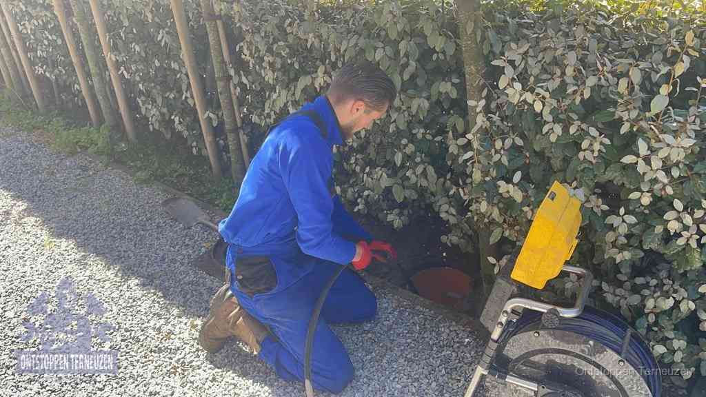 Monteur aan het werk bij een rioolput, de werkwijze voor riool ontstoppen in Terneuzen Monteur aan het werk bij een rioolput, de werkwijze voor riool ontstoppen in Terneuzen