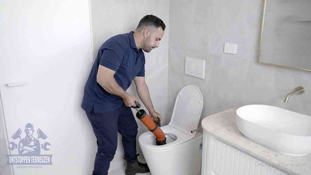 Een monteur gebruikt een handmatige perspomp (toiletontstopper) op een wandcloset tijdens het professioneel wc ontstoppen in Terneuzen Een monteur gebruikt een handmatige perspomp (toiletontstopper) op een wandcloset tijdens het professioneel wc ontstoppen in Terneuzen